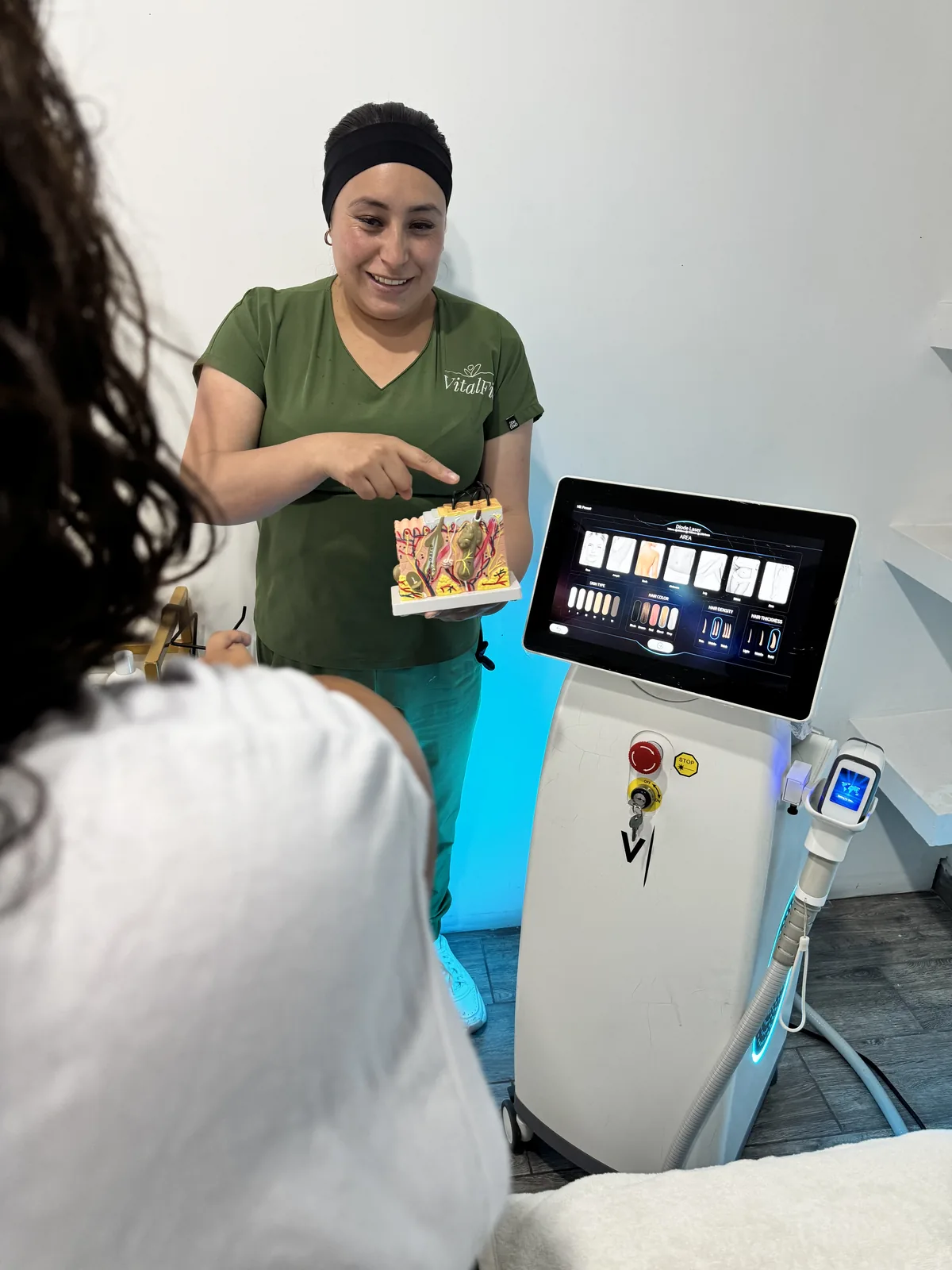 Una terapeuta de VitalFit explica con un modelo anatómico cómo actúa la depilación láser sobre la piel.